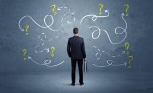 Unsure businessman with question marks